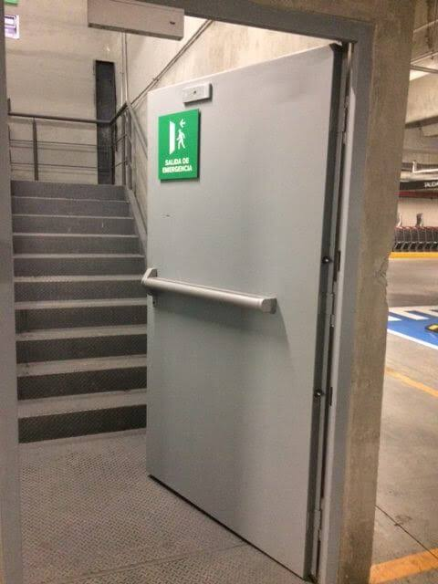 Puerta de salida de emergencia con barra antipánico instalada