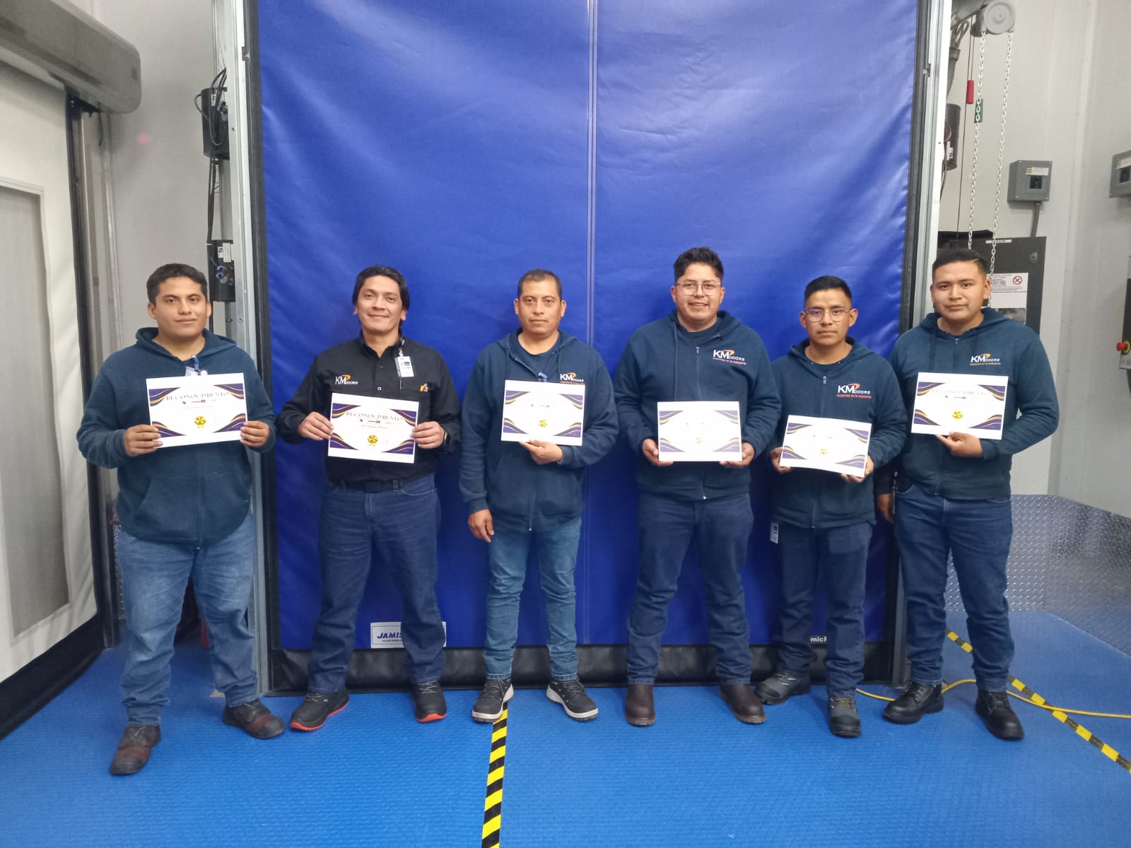 Equipo KMDoors con reconocimientos de participación en capacitación de equipos